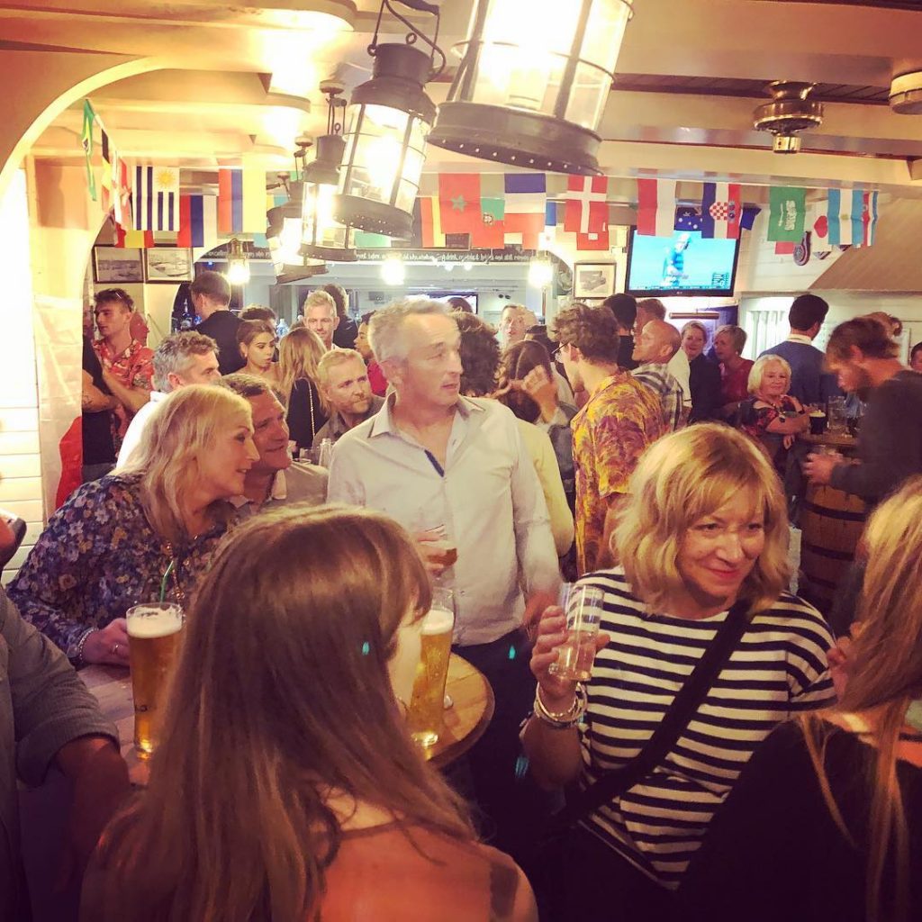 Revellers at the trafalgar inn watching a musician